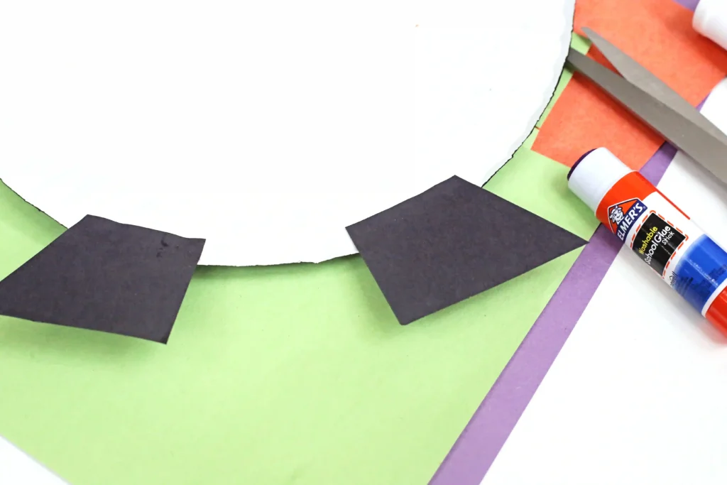 black construction paper glued to the back of a paper plate