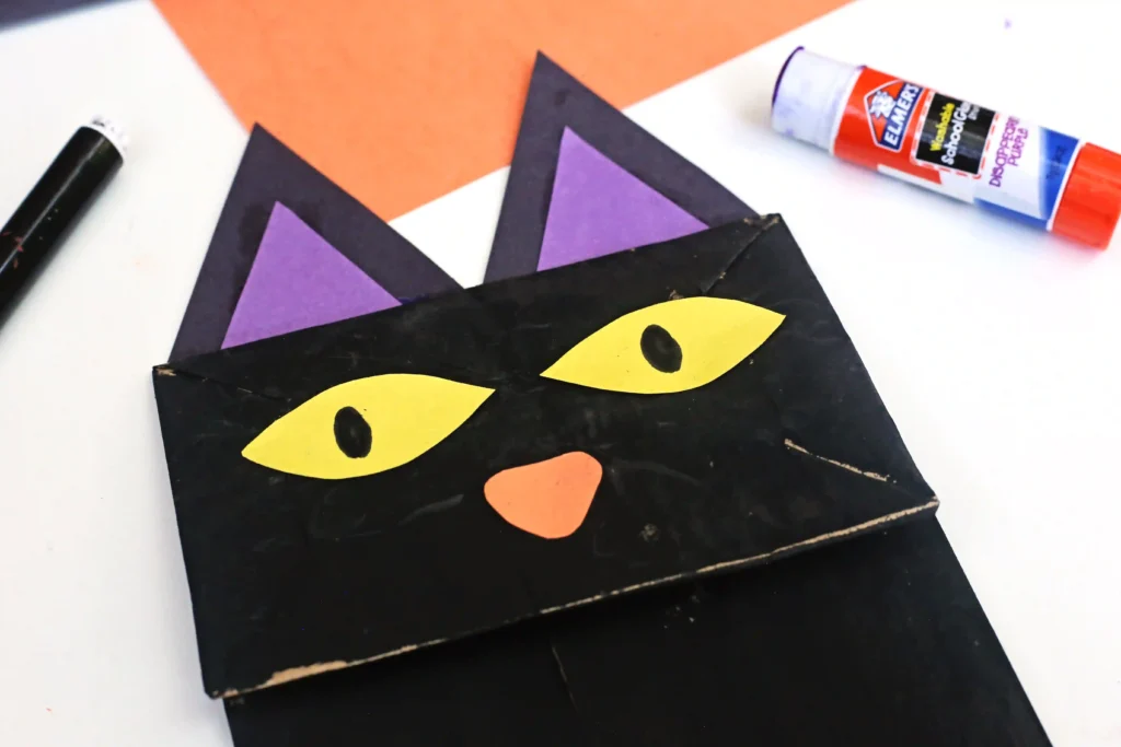 a paper bag painted black and decorated to look like a cat
