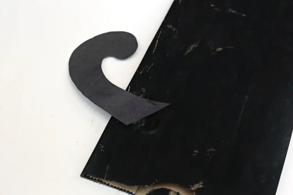 a paper bag painted black with a black construction paper tail