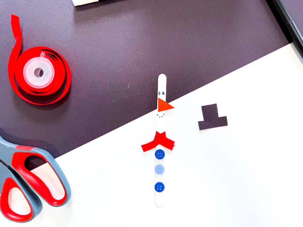 popsicle sticks painted and decorated to look like snowmen