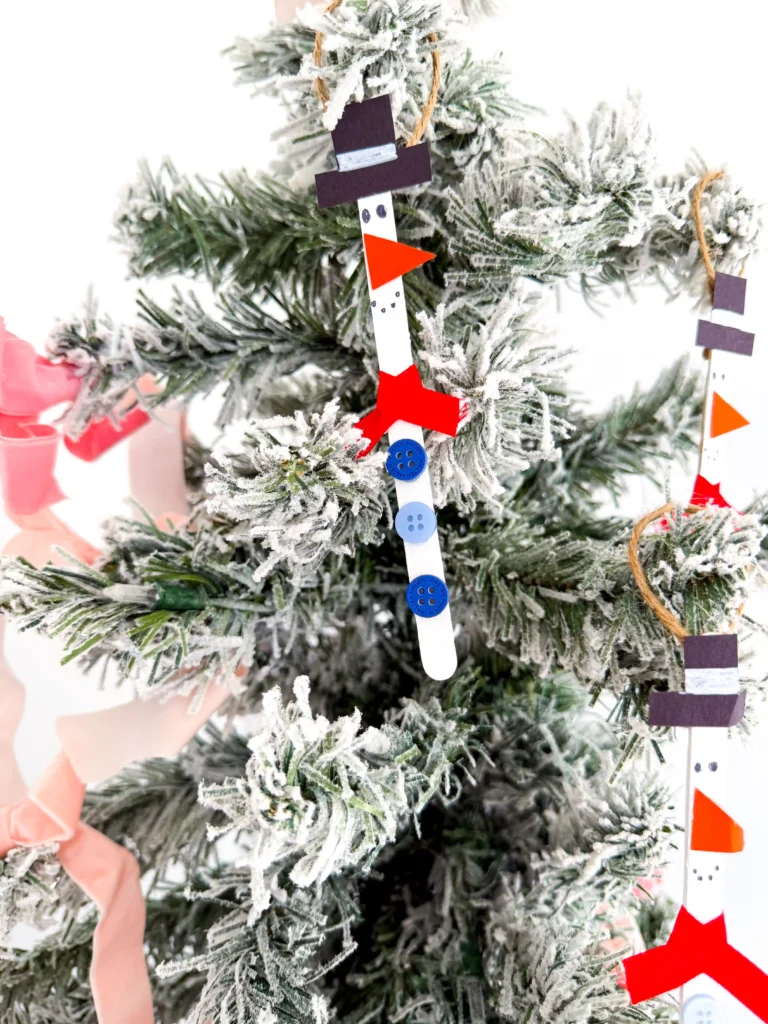 popsicle sticks painted and decorated to look like snowmen