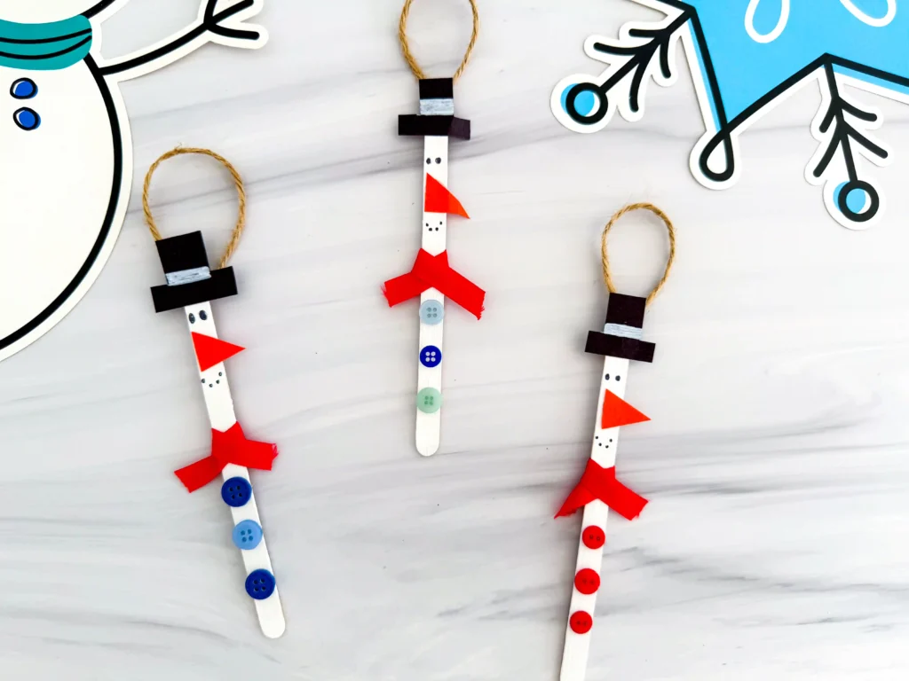 popsicle sticks painted and decorated to look like snowmen