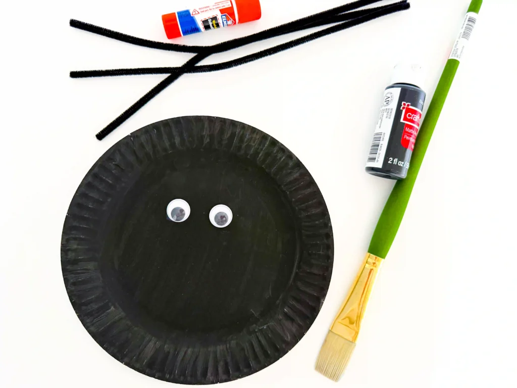 googly eyes glued on a plate painted black