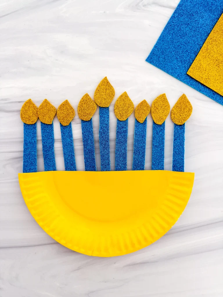 a paper plate painted yellow with glittery candles to look like a menorah