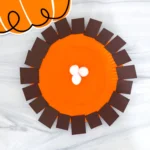 a paper plate painted orange and decorated to look like pumpkin pie