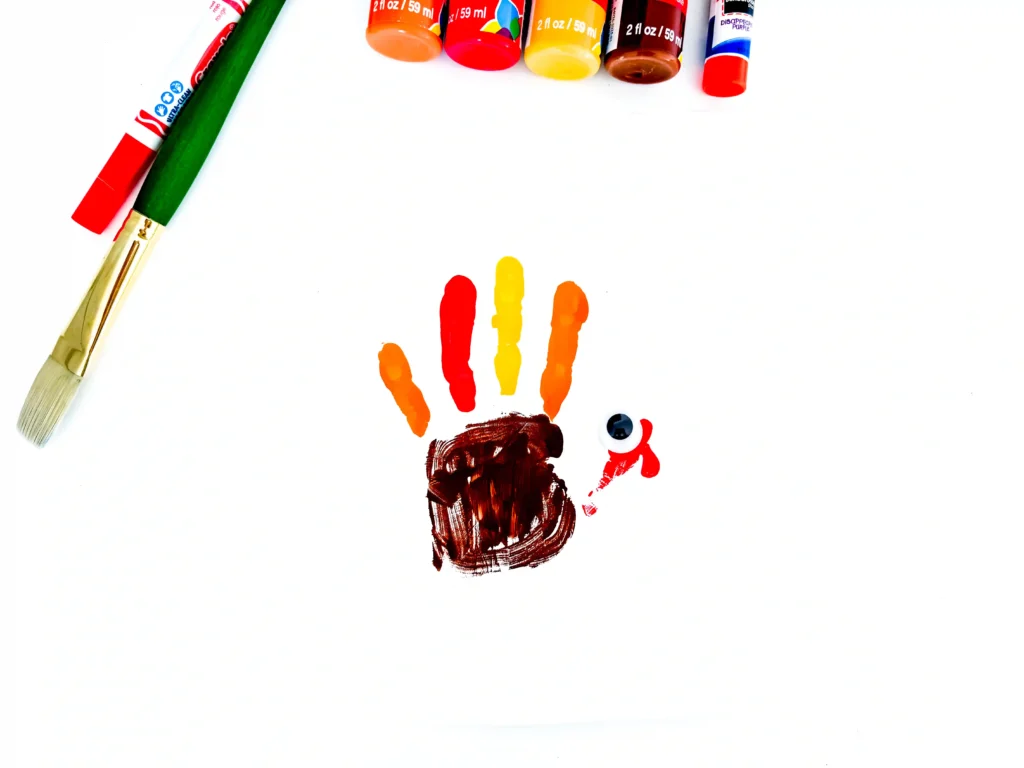 a turkey handprint craft of a painted handprint with googly eyes