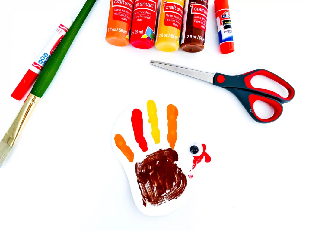 a turkey handprint craft of a painted handprint with googly eyes