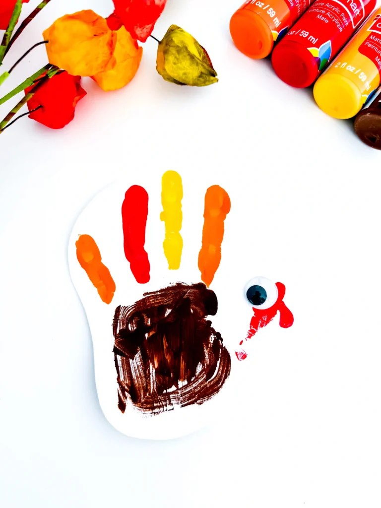 a turkey handprint craft of a painted handprint with googly eyes