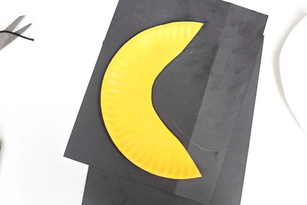 a paper plate cut to look like a moon and painted yellow