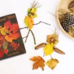 a man made out of leaves and sticks next to the book the leaf man