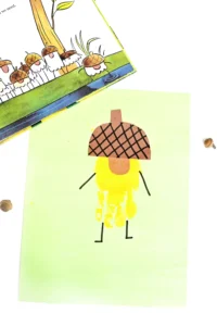 a handprint craft that is a yellow acorn with an orange nose
