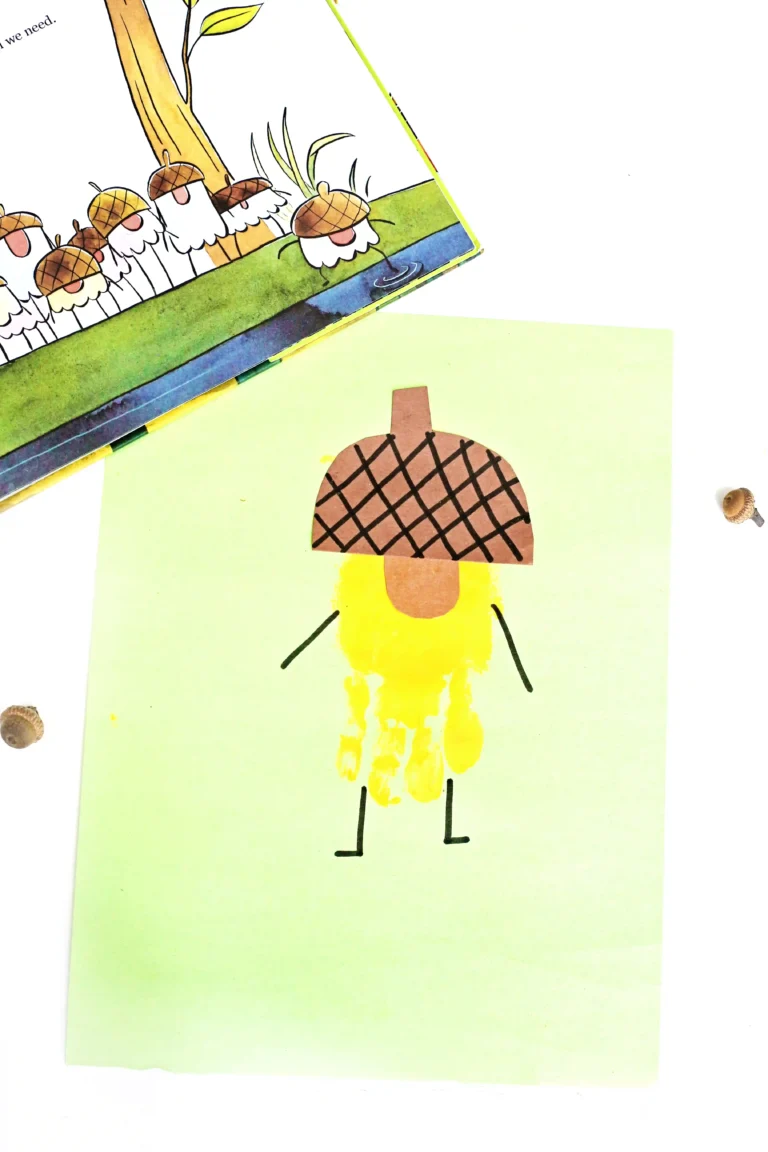 a handprint craft that is a yellow acorn with an orange nose