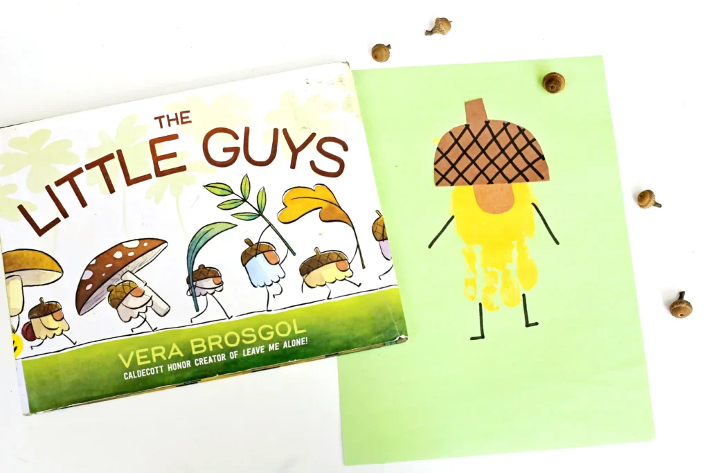 a handprint craft that is a yellow acorn with an orange nose