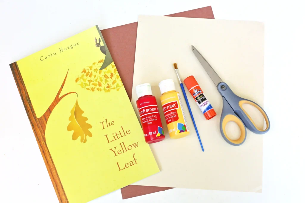 supplies for the little yellow leaf handprint craft: construction paper, red and yellow paint, paintbrush, glue, and scissors