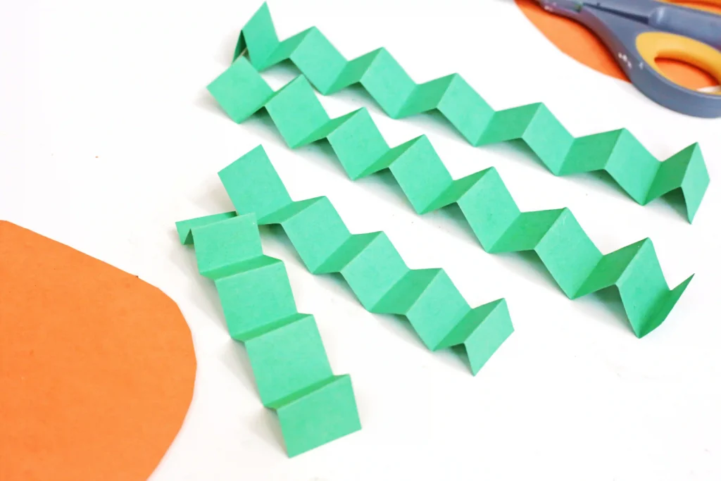 green construction paper strips folded to look like an accordian