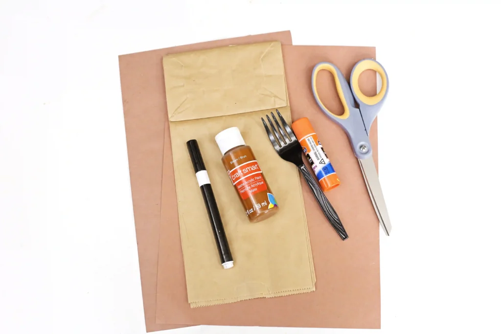 supplies for the bear says thanks paper bag craft: brown construction paper, a paper bag, brown paint, a fork, glue, scissors, and a black marker