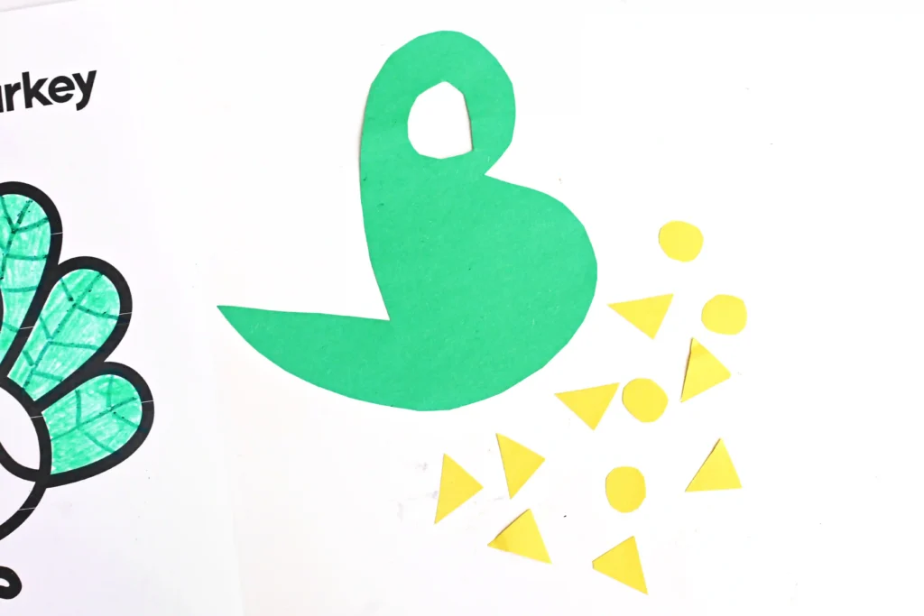 a dinosaur body and yellow triangles cut out of construction paper