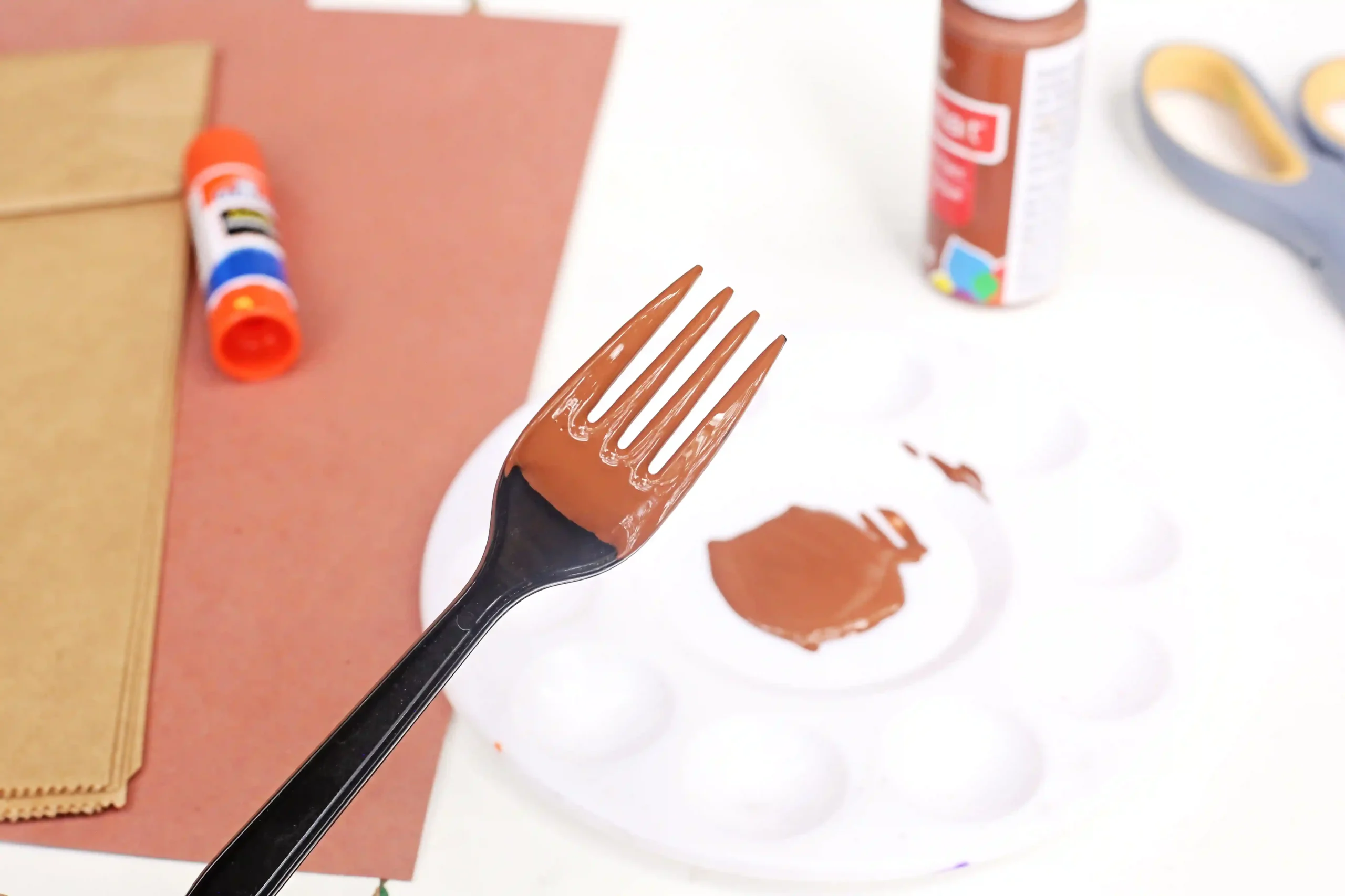 a plastic fork with brown paint on it