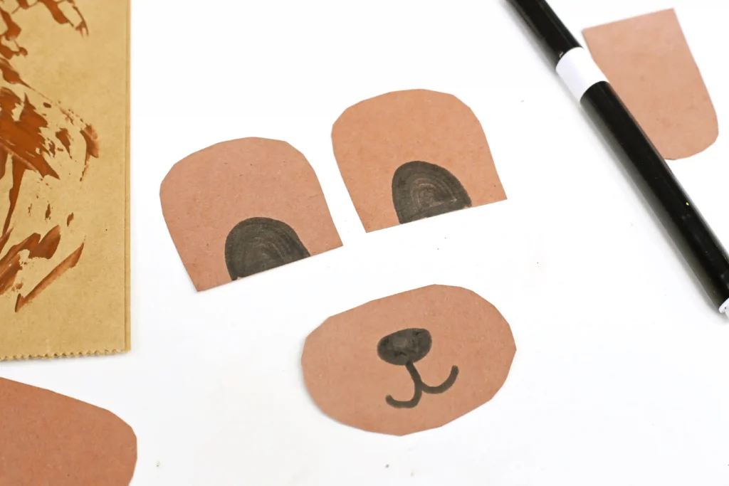 a bear snout, ears, and arms cut out of brown construction paper
