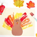 a turkey made out of construction paper with feathers painted on