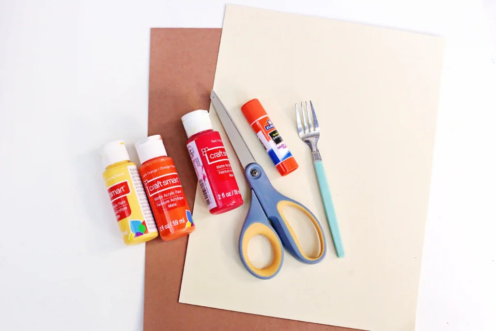 supplies for the fork painted turkey- brown and tan construction paper, scissors, glue, a fork, and red, orange, and yellow paint