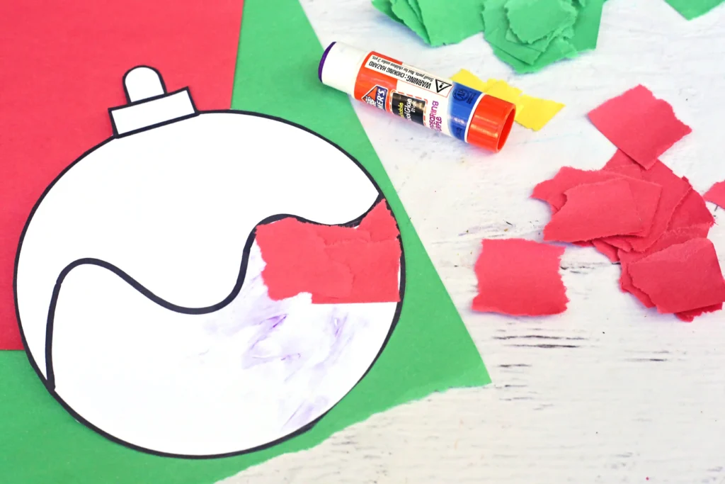 an ornament cut out of paper with red torn construction paper glued on